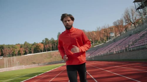 Bearded Caucasian Athlete in Sportswear Running on Professional Sport Stadium Outdoors Jogging