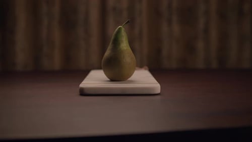 A Fresh Pear Beautifully Presented on a Wooden Cutting Board Ready for Use in Cooking