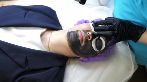 Aesthetician Removing Black Mask From Woman's Face