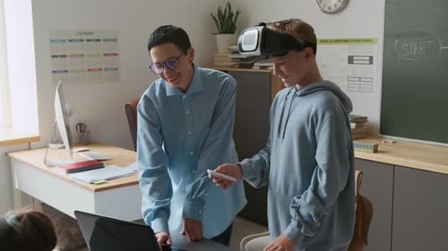 Boy Trying VR Glasses, Teacher Guiding him During IT Class in School