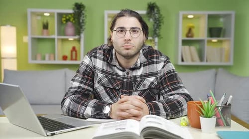 Man with Glasses Sitting at Desk with Laptop