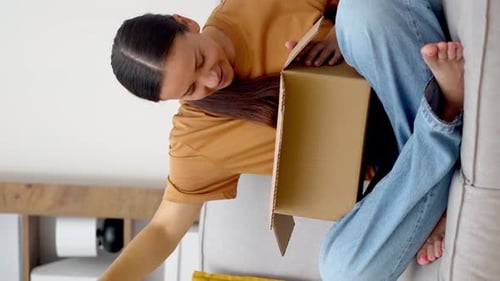 Woman Opening Package at Home on Couch