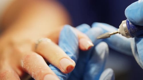 Close-Up of Manicure Shaping Nails with Tool