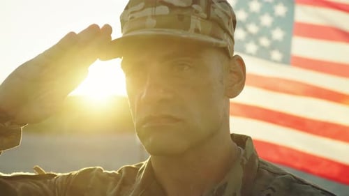 Soldier Saluting with American Flag at Sunrise