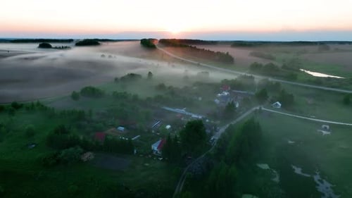 Aerial panoramic view of a foggy rural village at sunrise
