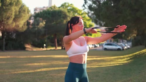 Outdoor Fitness Session With Resistance Bands in a Park on a Sunny Day