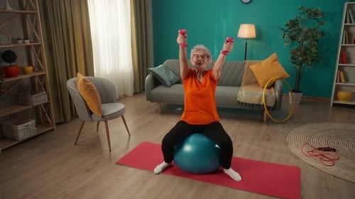 Senior Woman Exercising with Dumbbells on Stability Ball