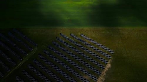 See Solar Panels in a Sunlit Field From an Aerial View Highlighting Renewable Energy and