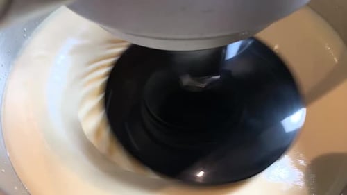 La batidora de primer plano se agita con un movimiento circular orbital, la masa para tartas