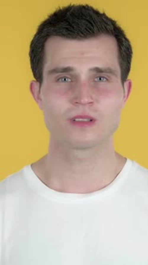 Hombre triste y molesto, fondo amarillo, vídeo vertical