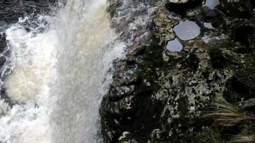 Majestic Waterfall Flowing Over Mossy Rocks