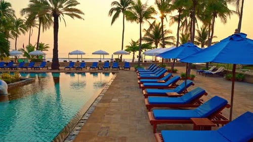 beautiful palm tree with umbrella chair pool in luxury hotel resort at sunrise times
