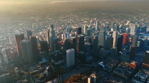 Approaching downtown of Los Angeles from top. View of the metropolis covered with thick mist.