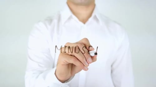 Man Writes 'Mindset' on Clear Surface