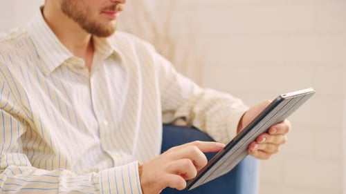 Close up of Caucasian businessman using digital tablet in living room.