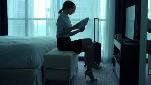 Young businesswoman analyzes financial data in luxury hotel room bed