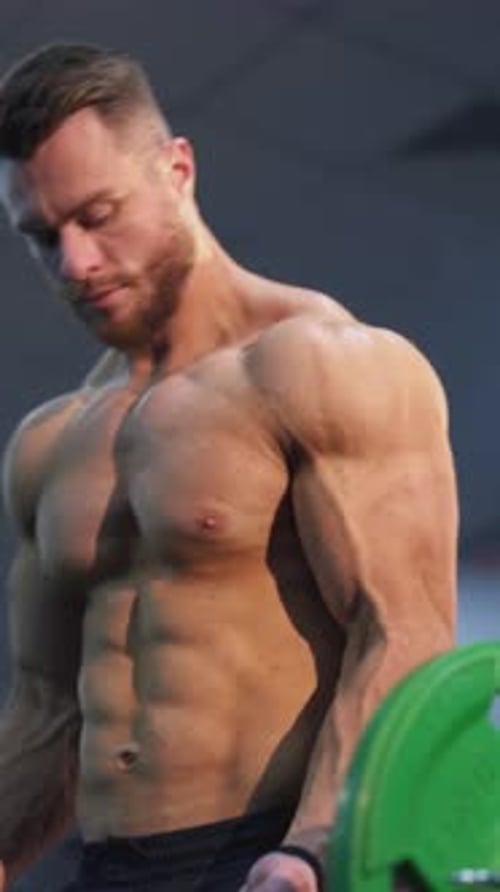 Muscular Man Lifting Weights at the Gym