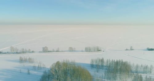 Luftaufnahme der kalten Winterlandschaft, arktische Felder, Bäume, bedeckt mit Frost, Schnee, Eis, Fluss und Sonne
