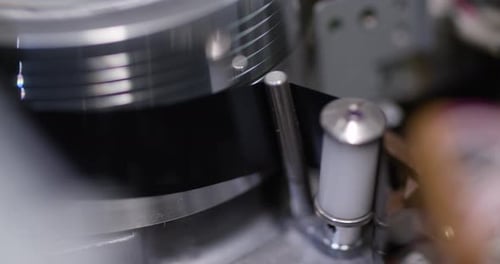 Tight close-up shot of a vintage VHS tape recorder - record starts loading mechanism put tape on the