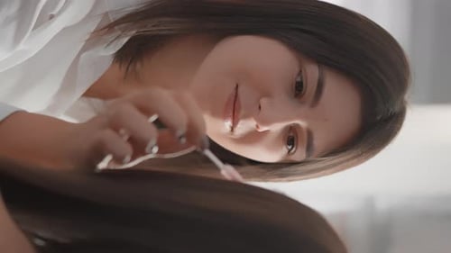 Woman Cutting Long Hair with Scissors