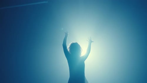 Silhouette of Curly Haired Woman Dancing in Blue Fog