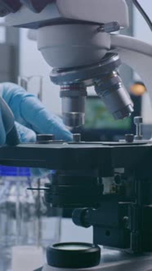 Close Up of Professional Scientist Putting Slide with Test Sample Under Microscope