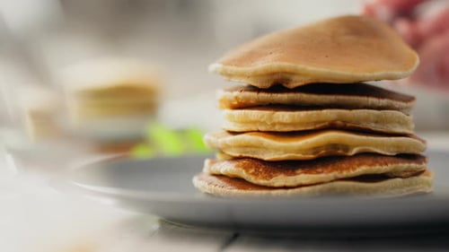 Stack of Pancakes Being Piled High on Plate