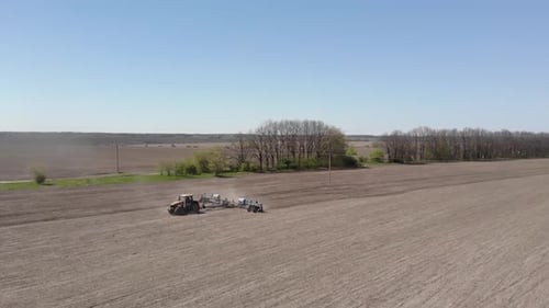 Big yellow tractor planting corn in Ukraine. Tractor working on the field