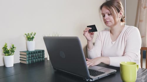Young Woman Enters Credit Card Information On Laptop