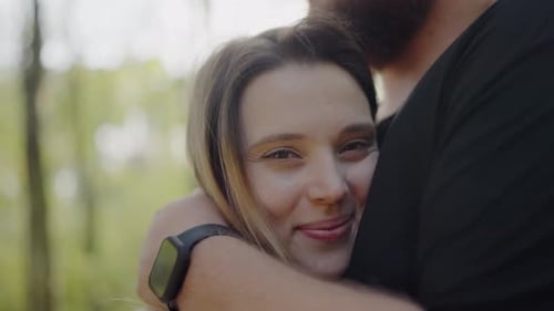 Loving Couple Embraces Under Sunlight in a Serene Park Setting