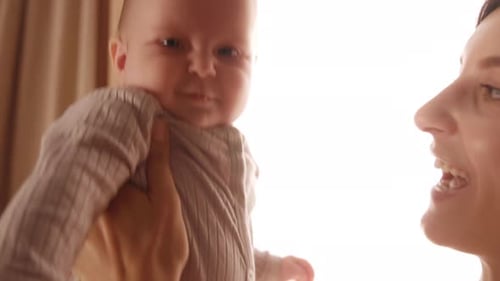 Happy Baby Interacts with Loving Parent Indoors