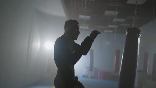 Motivation Sportlicher Kämpfer trainiert seine Schläge und Verteidigung in der Boxhalle ein Mann Boxer trainiert Streik