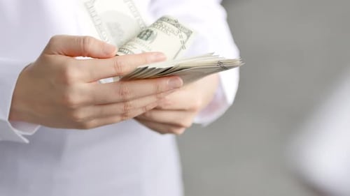 Hands Counting Stack of US Hundred Dollar Bills