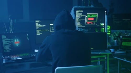 A Mysterious Hacker Engaged in Intriguing Work Within a Dark Room Surrounded By Multiple Monitors