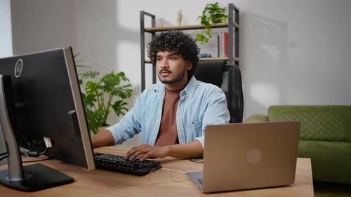 Un programmeur aux cheveux pervers travaille sur un ordinateur à domicile