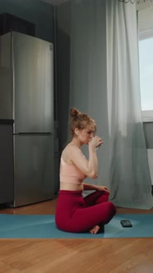 Woman Drinking Water after Workout on Yoga Mat