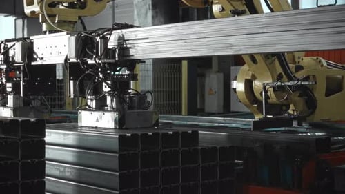 Un gran robot manipulador automatizado descarga piezas pesadas de acero de una línea transportadora Automation en