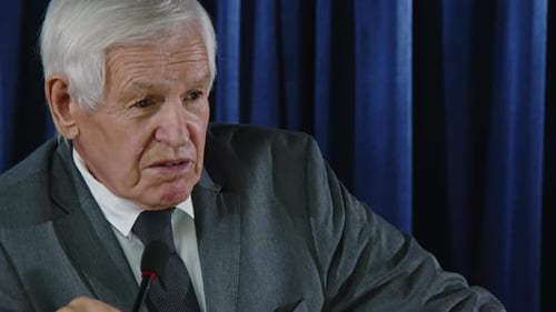 Man Speaking at a Conference into Microphone