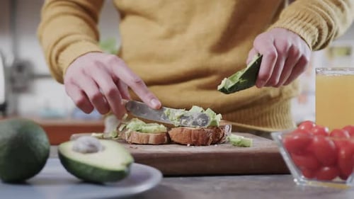 Person making avocado toast with a knife