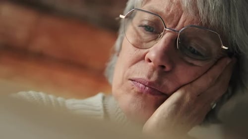 Sad Elderly Woman With Reading Glasses