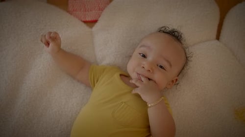 Adorable Infant Lying Down in Yellow Shirt