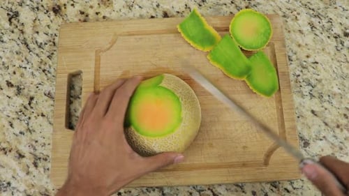 Removing peel from melon using sharp knife. Top view.