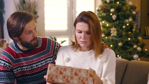 Caucasian Romantic Couple Exchange Gifts Near Christmas Tree Young Disappointed Woman Shaking Her