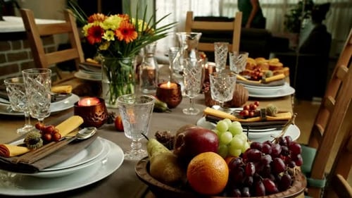 Thanksgiving Table with Flowers, Candles, Fruit, Plates, and Glasses