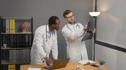 Doctors Collaborate, Analyze X-Ray Results in Modern Office