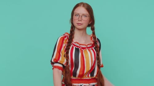 Rothaariges Mädchen zeigt in die Kamera und schaut mit verspieltem, fröhlichem Gesichtsausdruck, Wahl treffen Hey du