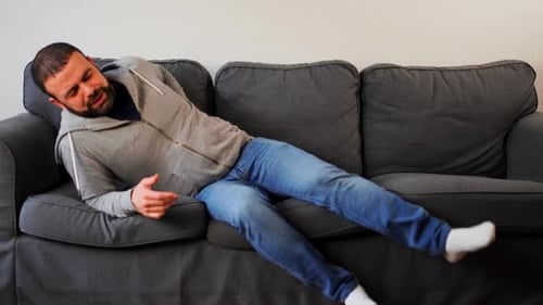 Man Relaxes and Lies Down on Couch