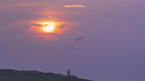 Coastal Sunset with Lighthouse Silhouette.