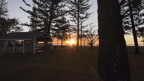 Orange Sunset, on Scarborough Beach, with silhouettes of people walking, Brisbane, Queensland
