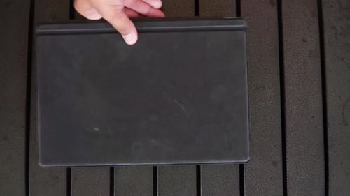 Close-up of hand arranging smartphone and tablet on desk, digital device lifestyle theme.